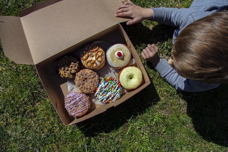 doughnuts in box with a young boy north fork doughnut co