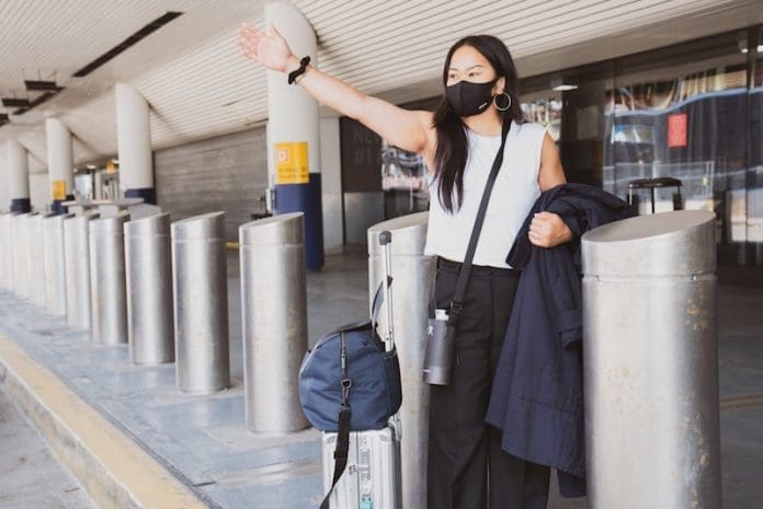 girl traveling at airport pickup wearing black face mask