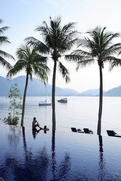 infinity pool near Indian ocean with palm trees blue skies tropical