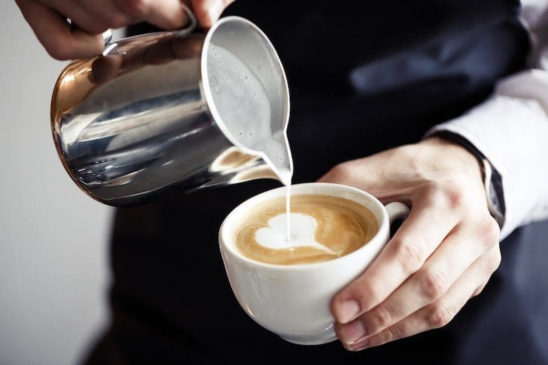 barista making a cappuccino heart shaped foam