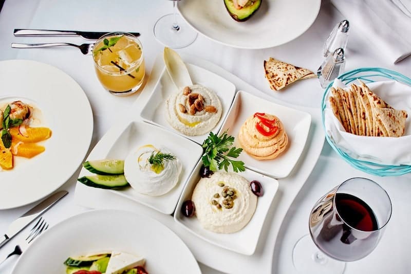 greek mezze dining on white tablecloth