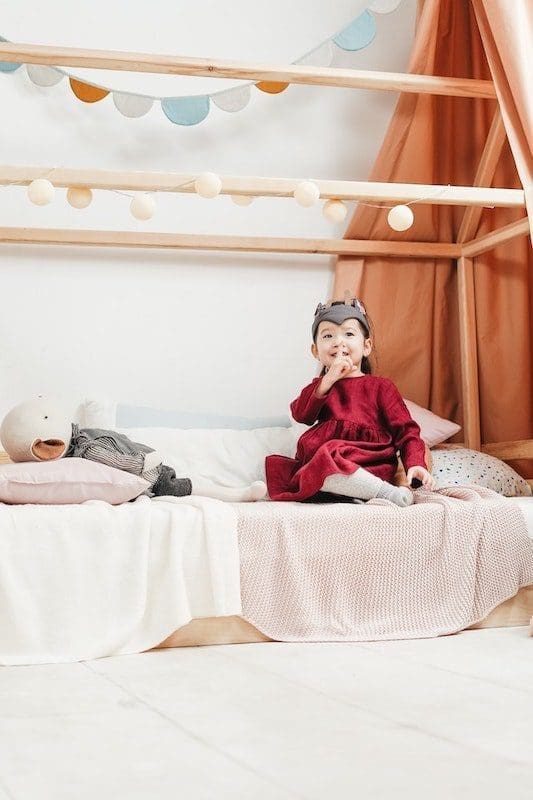 Girl in Red Dress Sitting on Bed