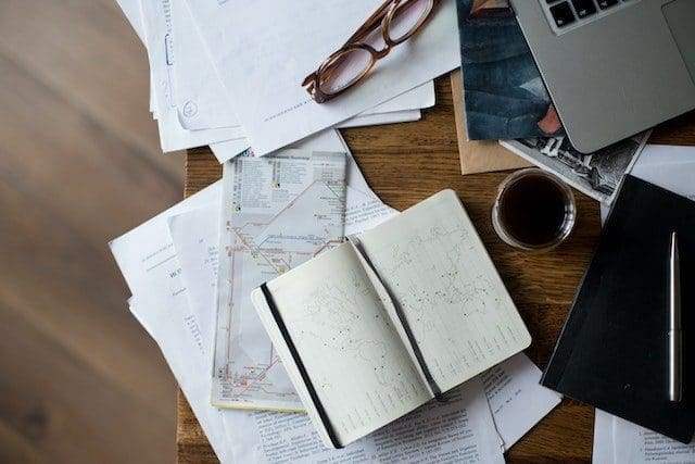 Brown Framed Eyeglasses on White Printer Paper Beside White Ceramic Mug