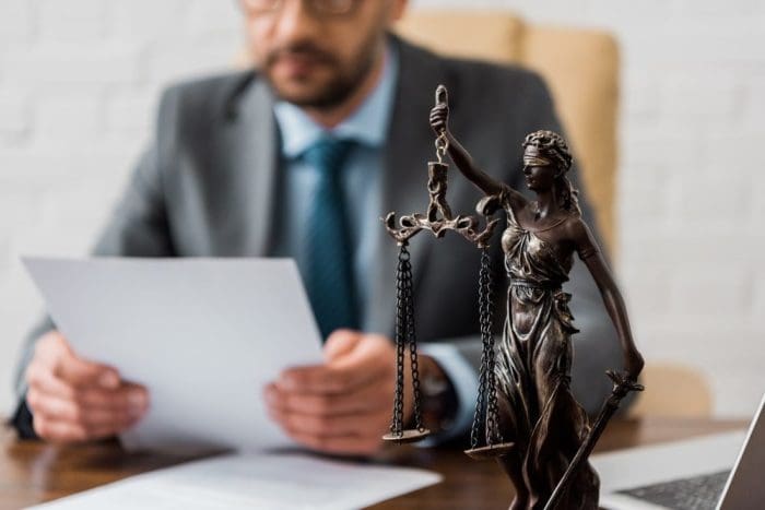 Close-up view of lady justice statue and lawyer working working