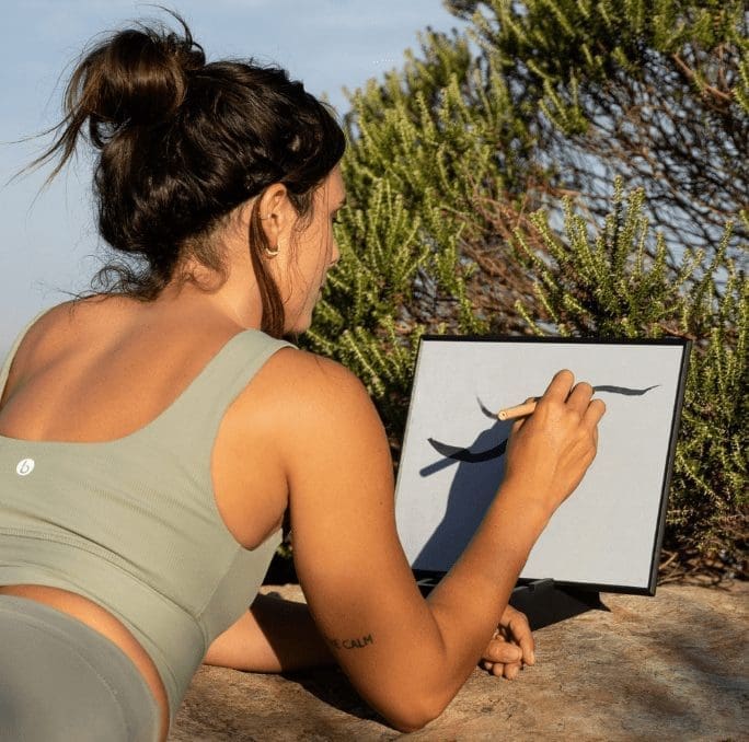 brunette woman using Original Buddha Board in Nature