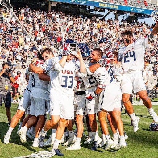 winning lacrosse team huddled together on field