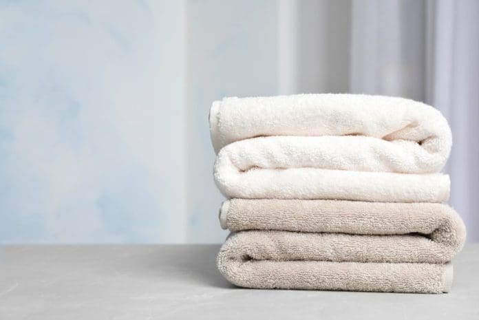Stack of soft bath towels on table against blurred background