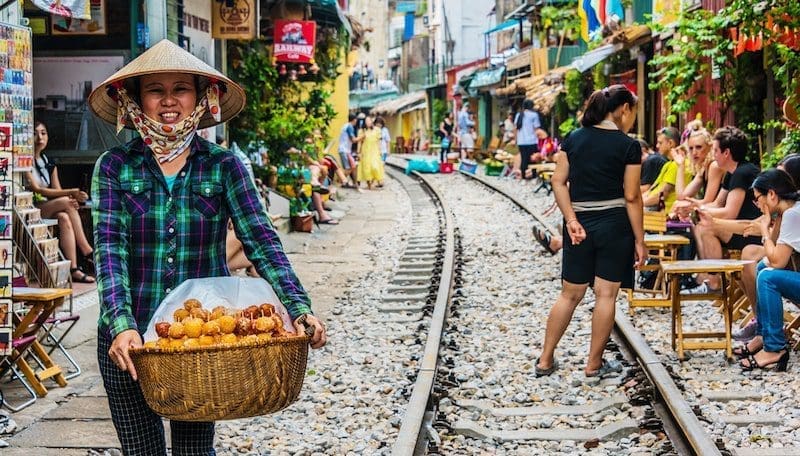 Vietnamese woman selling cookie onTrain Street in Hanoi