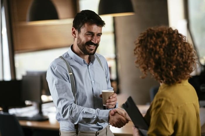 Colleagues shaking hands at office