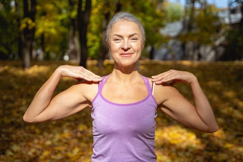 Contented Caucasian woman working out her shoulders