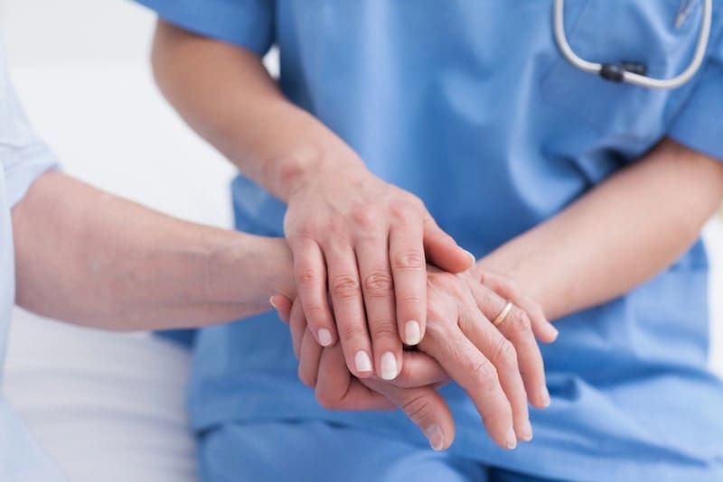 Close up of a nurse touching hand of a patient