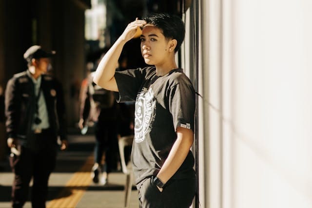 Model in a Black T-shirt with Aape Print on a Sidewalk